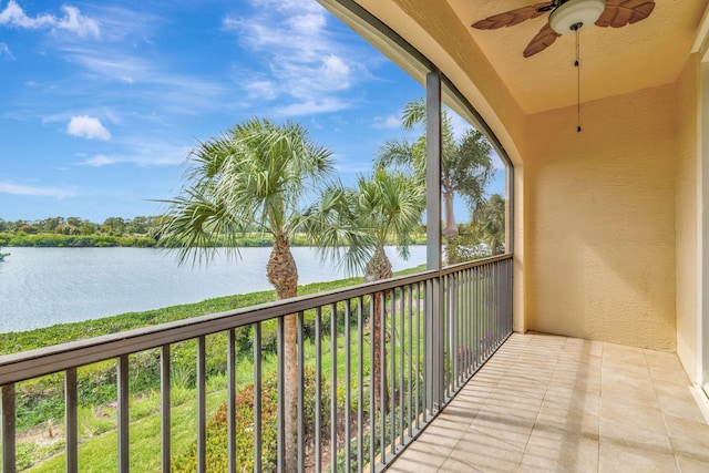 balcony with a water view and a ceiling fan