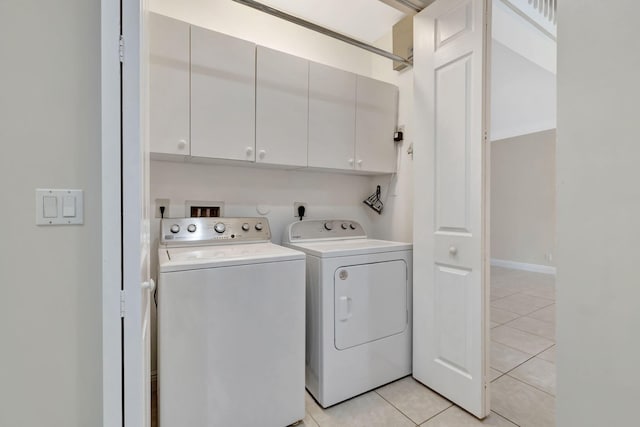 laundry room featuring washer and clothes dryer, cabinet space, and light tile patterned floors