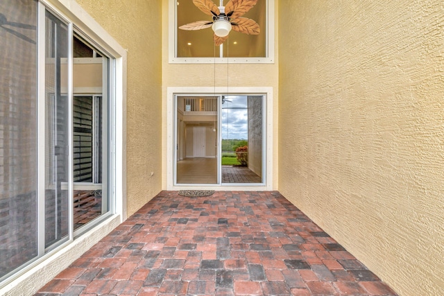 property entrance with stucco siding and ceiling fan