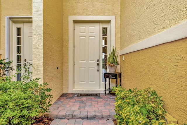doorway to property featuring stucco siding