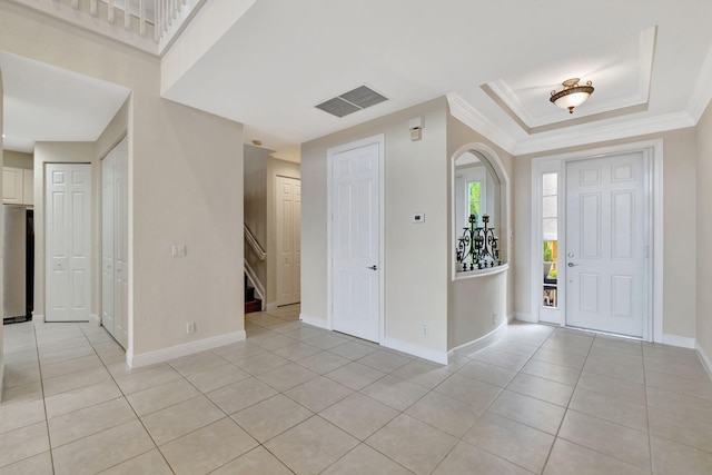 entrance foyer with crown molding, baseboards, and light tile patterned flooring