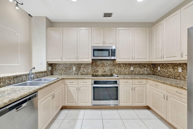 kitchen featuring a sink, stainless steel appliances, light tile patterned floors, tasteful backsplash, and visible vents