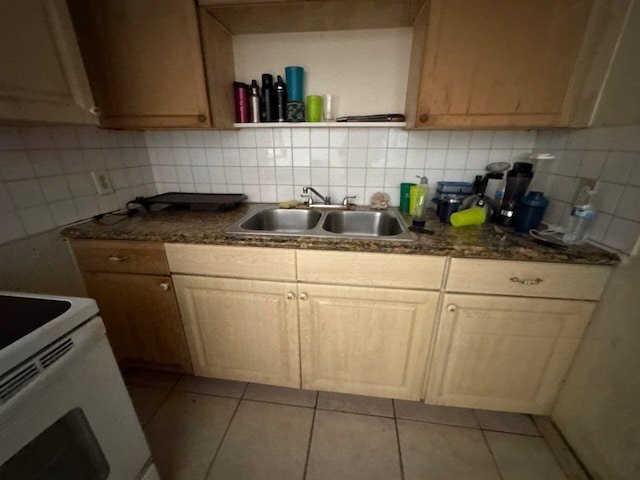 410 S F St, Lake Worth, FL 33460 - kitchen featuring dark countertops, backsplash, light tile patterned floors, and a sink