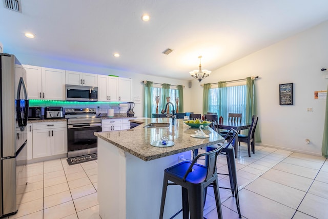 kitchen with a sink, a chandelier, stainless steel appliances, lofted ceiling, and visible vents