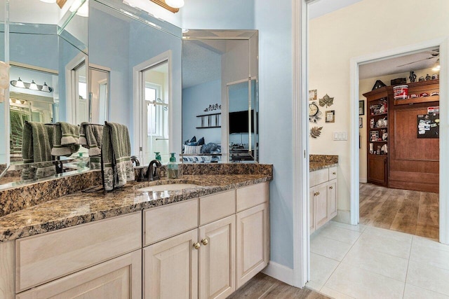 ensuite bathroom featuring vanity, ensuite bathroom, wood finished floors, and a closet