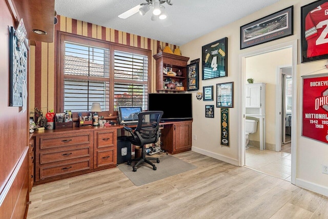 office space featuring a textured ceiling, ceiling fan, and light wood finished floors