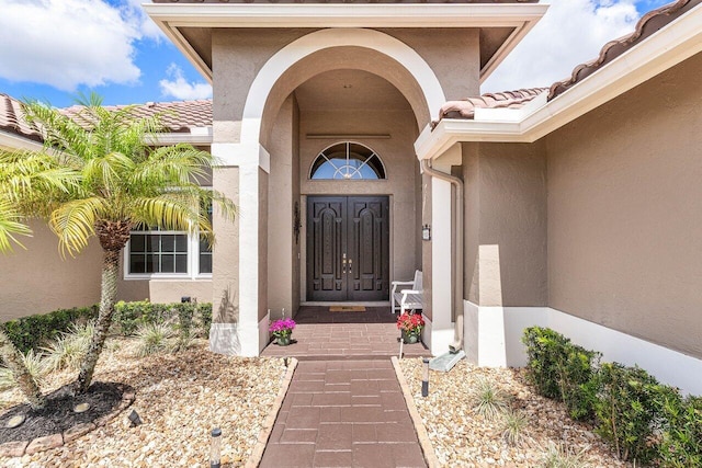 property entrance featuring stucco siding and a tiled roof