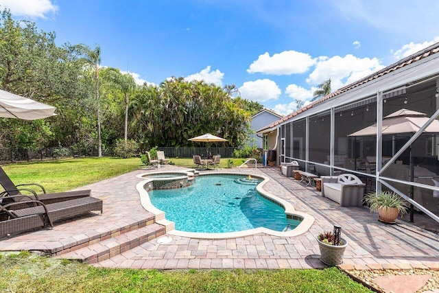 view of swimming pool with a lawn, a pool with connected hot tub, fence, and a patio area