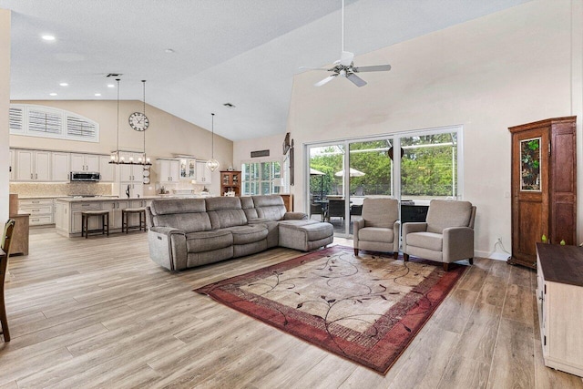 living area featuring recessed lighting, high vaulted ceiling, ceiling fan with notable chandelier, and light wood-type flooring