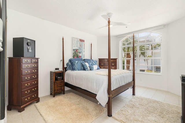 bedroom with light tile patterned flooring, ceiling fan, and a textured ceiling