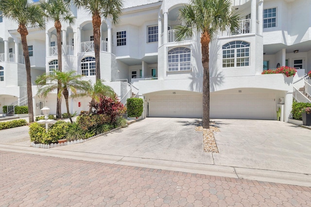 view of front of house featuring driveway, an attached garage, and stucco siding