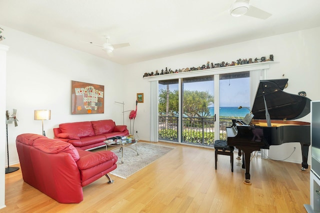 living room featuring ceiling fan, wood finished floors, and baseboards