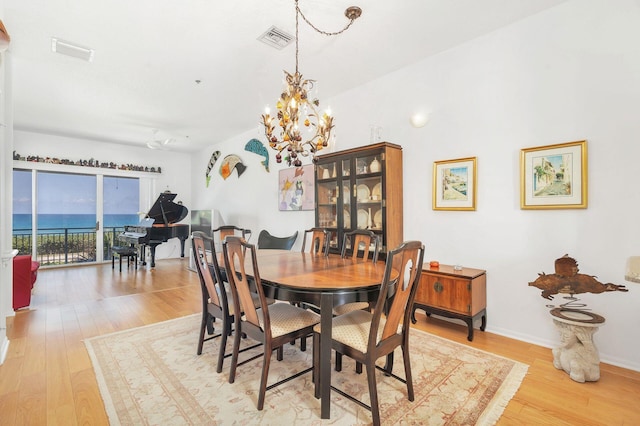 dining area featuring light wood-type flooring and a chandelier