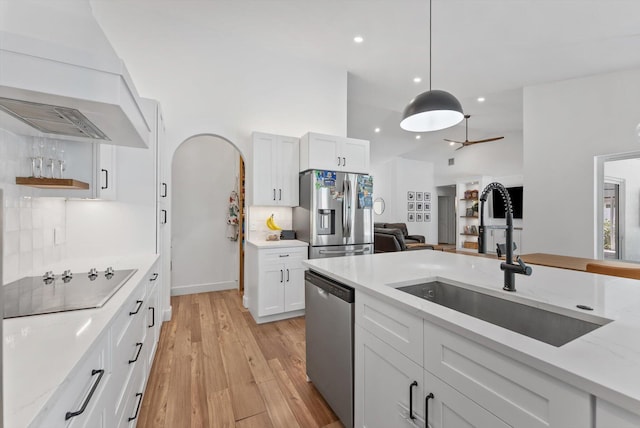 kitchen featuring recessed lighting, white cabinetry, a sink, light wood-style flooring, and stainless steel appliances