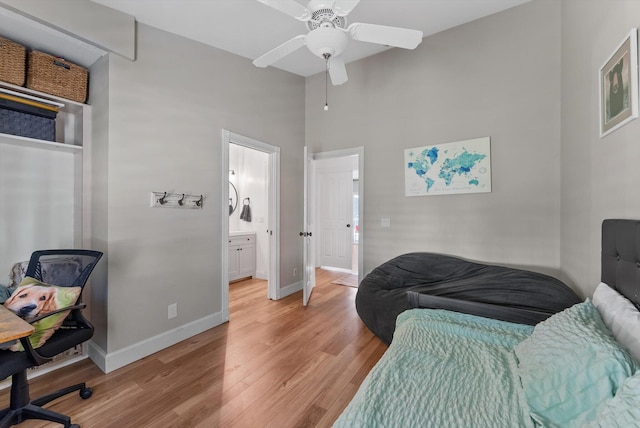 bedroom with baseboards, a ceiling fan, light wood-type flooring, and a towering ceiling