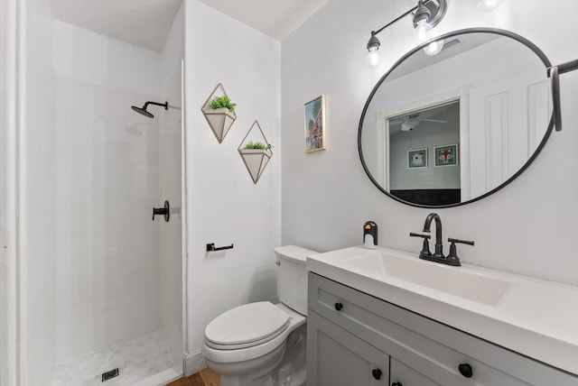 bathroom with vanity, toilet, and tiled shower