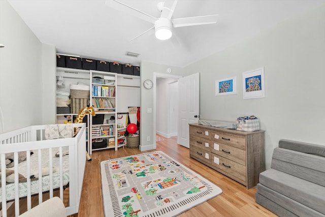 bedroom featuring ceiling fan, wood finished floors, and visible vents
