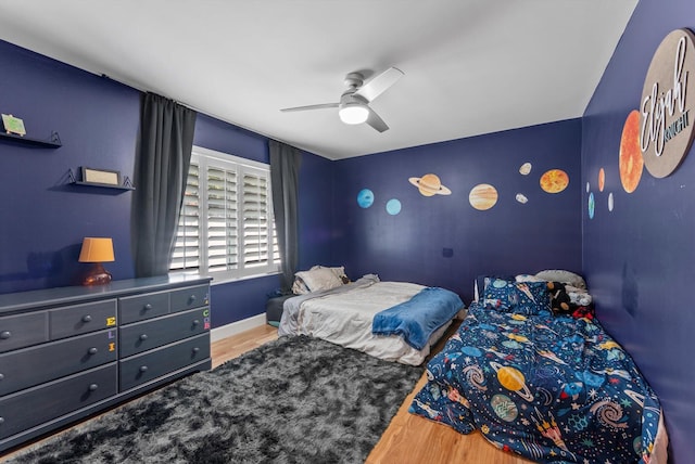 bedroom with baseboards, ceiling fan, and wood finished floors