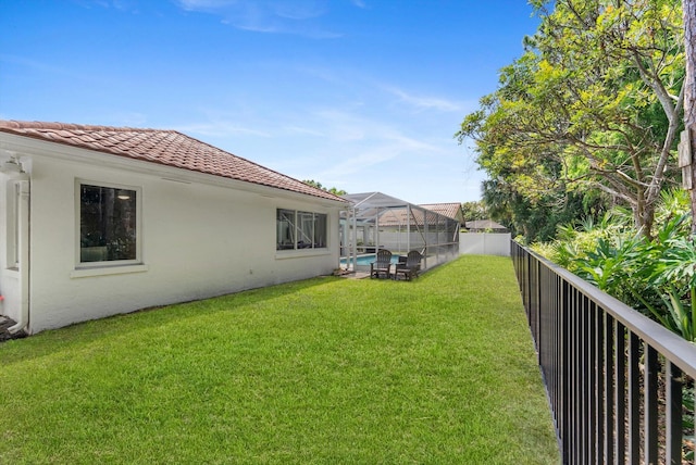 view of yard featuring glass enclosure, a fenced in pool, and a fenced backyard