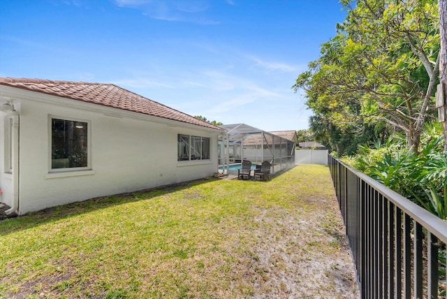 view of yard featuring a fenced backyard, a fenced in pool, and a lanai