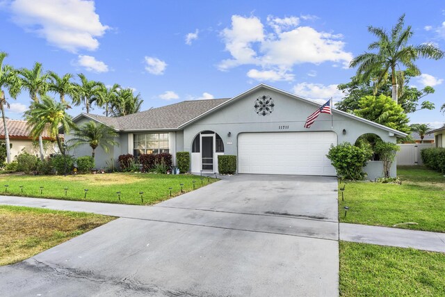 11711 Laurel Valley Cir, Wellington, FL 33414 - ranch-style house with concrete driveway, a front lawn, stucco siding, and an attached garage