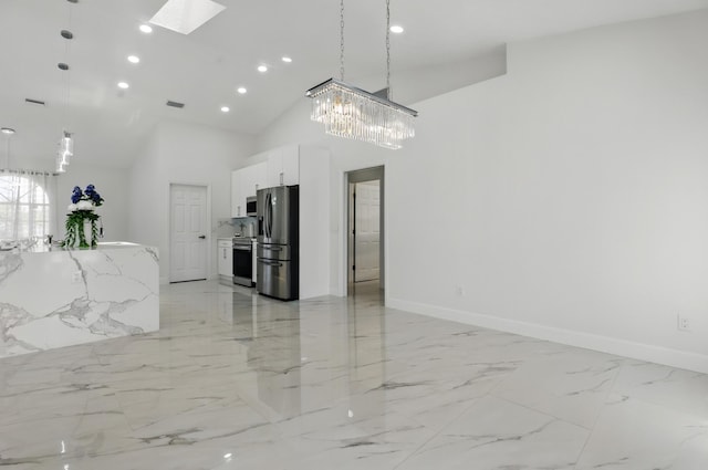 2449 SE Rock Springs Dr, Port Saint Lucie, FL 34952 - kitchen with stainless steel appliances, a skylight, white cabinets, light marble finish flooring, and baseboards