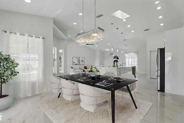2449 SE Rock Springs Dr, Port Saint Lucie, FL 34952 - dining space featuring recessed lighting, light marble finish flooring, a high ceiling, a skylight, and a chandelier