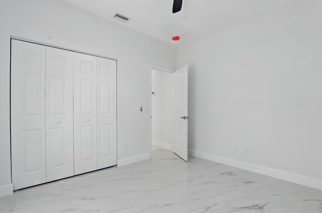 2449 SE Rock Springs Dr, Port Saint Lucie, FL 34952 - unfurnished bedroom with marble look tile flooring, baseboards, and a closet
