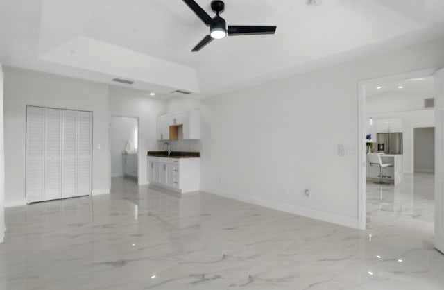 2449 SE Rock Springs Dr, Port Saint Lucie, FL 34952 - unfurnished living room with ceiling fan, baseboards, a sink, and light marble finish floors