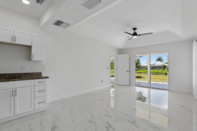 2449 SE Rock Springs Dr, Port Saint Lucie, FL 34952 - spare room featuring a tray ceiling, baseboards, ceiling fan, light marble finish floors, and recessed lighting