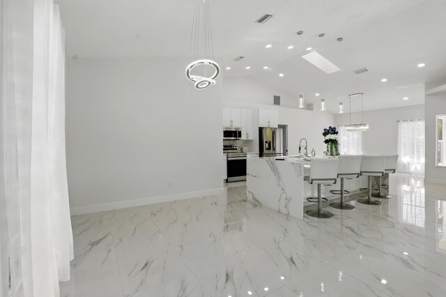 2449 SE Rock Springs Dr, Port Saint Lucie, FL 34952 - kitchen featuring appliances with stainless steel finishes, modern cabinets, white cabinetry, recessed lighting, and a skylight