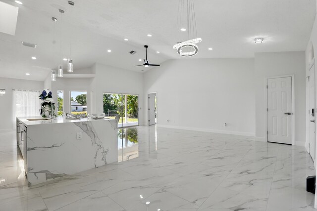 2449 SE Rock Springs Dr, Port Saint Lucie, FL 34952 - kitchen featuring recessed lighting, open floor plan, a spacious island, a sink, and light marble finish flooring