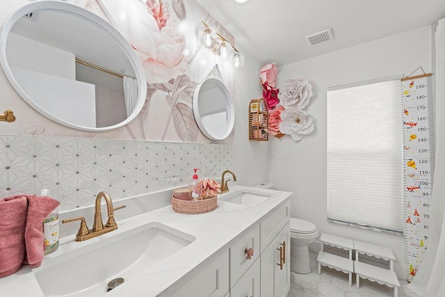 bathroom with a sink, tasteful backsplash, toilet, and visible vents