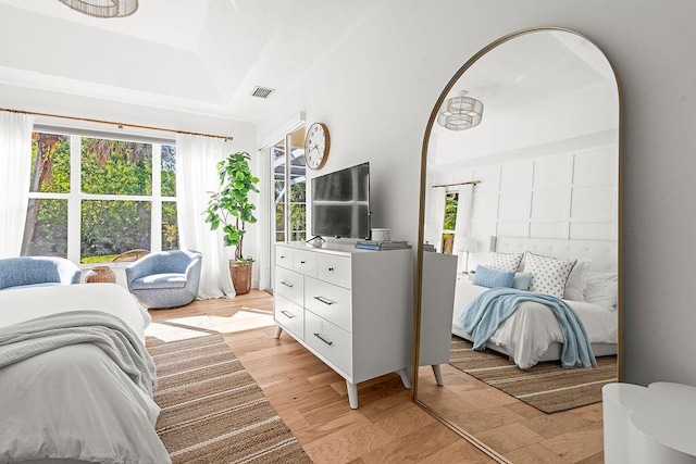bedroom featuring visible vents, arched walkways, and light wood-type flooring