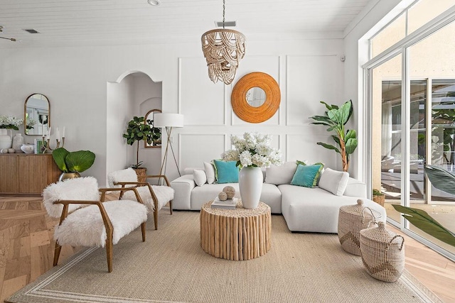 sunroom featuring arched walkways, a chandelier, and visible vents
