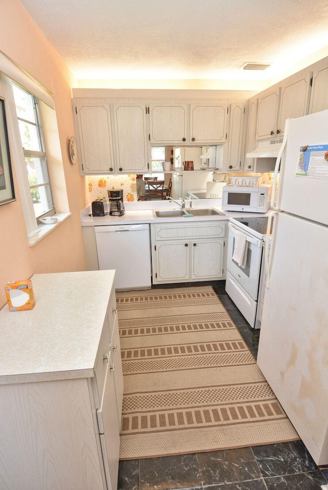 1225 NW 21st St Unit 2010, Stuart, FL 34994 - kitchen featuring marble finish floor, white appliances, light countertops, under cabinet range hood, and a sink