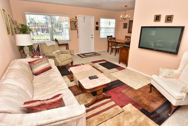 1225 NW 21st St Unit 2010, Stuart, FL 34994 - living room featuring an inviting chandelier, baseboards, and a healthy amount of sunlight