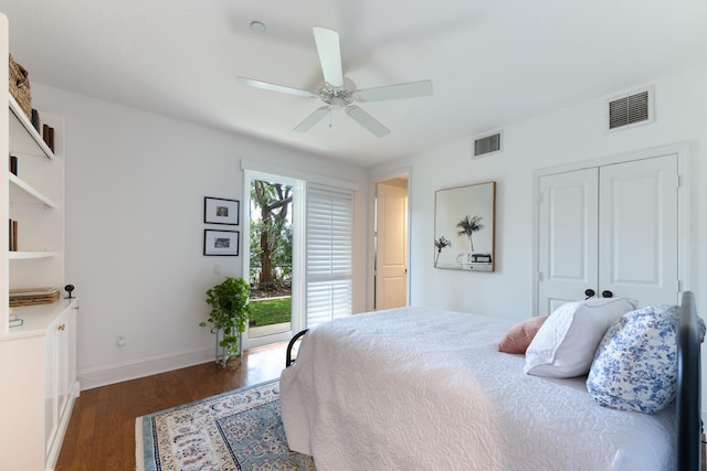 bedroom with baseboards, visible vents, dark wood finished floors, and a closet