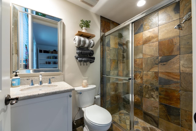 bathroom featuring vanity, a stall shower, visible vents, and toilet