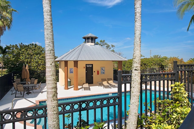 community pool featuring a patio and fence