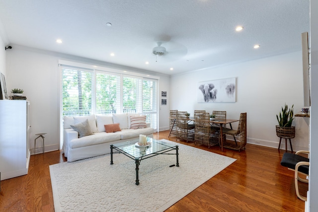 living area with baseboards, a ceiling fan, recessed lighting, and wood finished floors