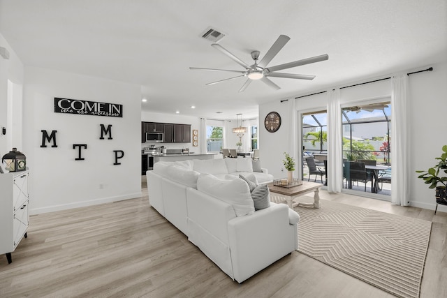 living room featuring ceiling fan, visible vents, light wood-type flooring, baseboards, and recessed lighting