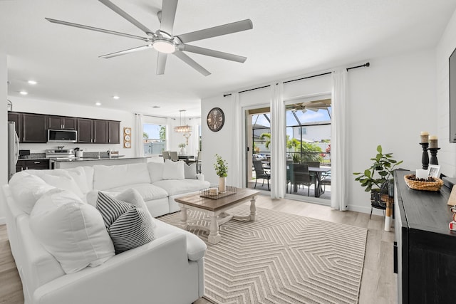 living room with ceiling fan, recessed lighting, and light wood-style flooring
