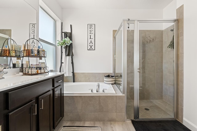 full bath featuring vanity, a stall shower, a bath, and wood finished floors
