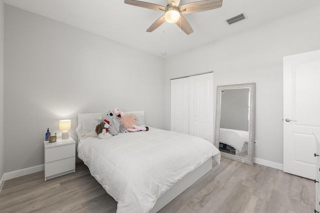 bedroom featuring visible vents, light wood finished floors, baseboards, and a closet