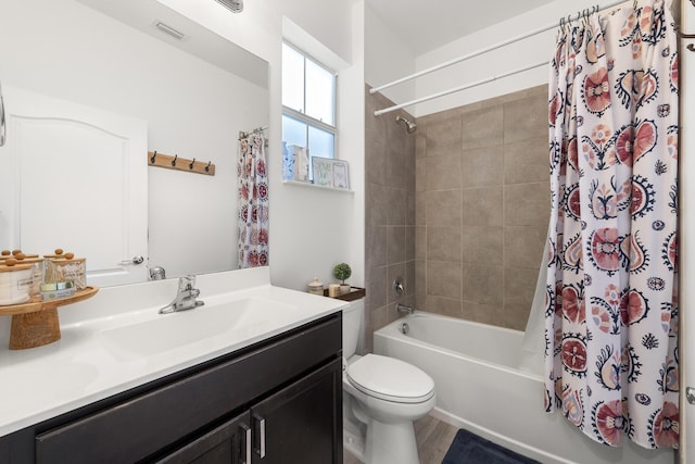 bathroom featuring visible vents, shower / bath combo with shower curtain, toilet, and vanity