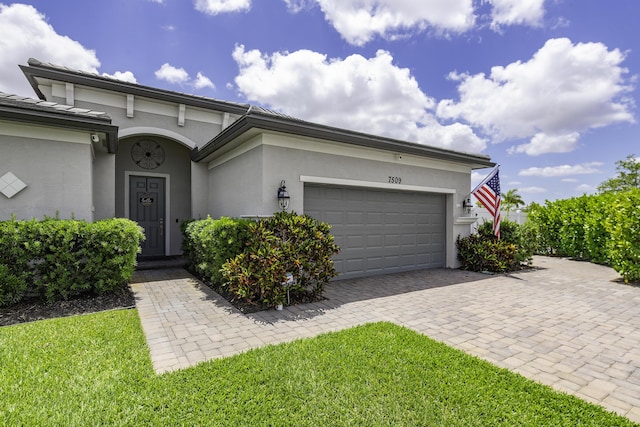 view of front facade featuring a garage, stucco siding, and driveway