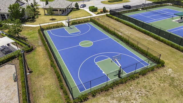 view of sport court with a lawn, community basketball court, and fence