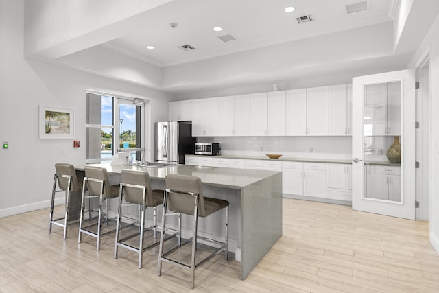 kitchen featuring visible vents, ornamental molding, appliances with stainless steel finishes, and a tray ceiling