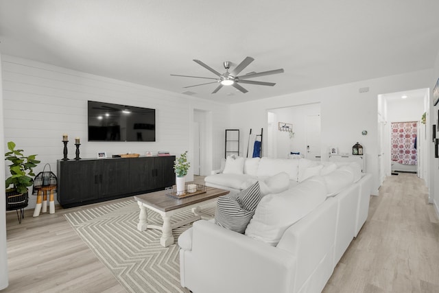 living room featuring a ceiling fan and light wood-style flooring